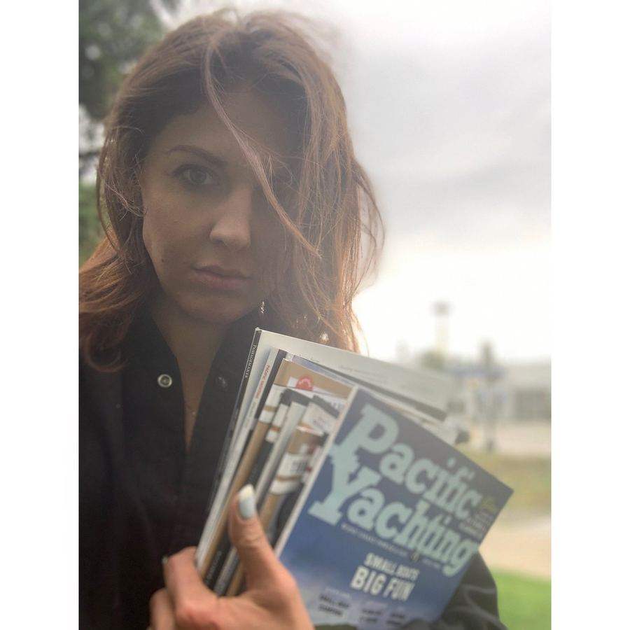 Whitney holding a boating magazine she cut for a commission